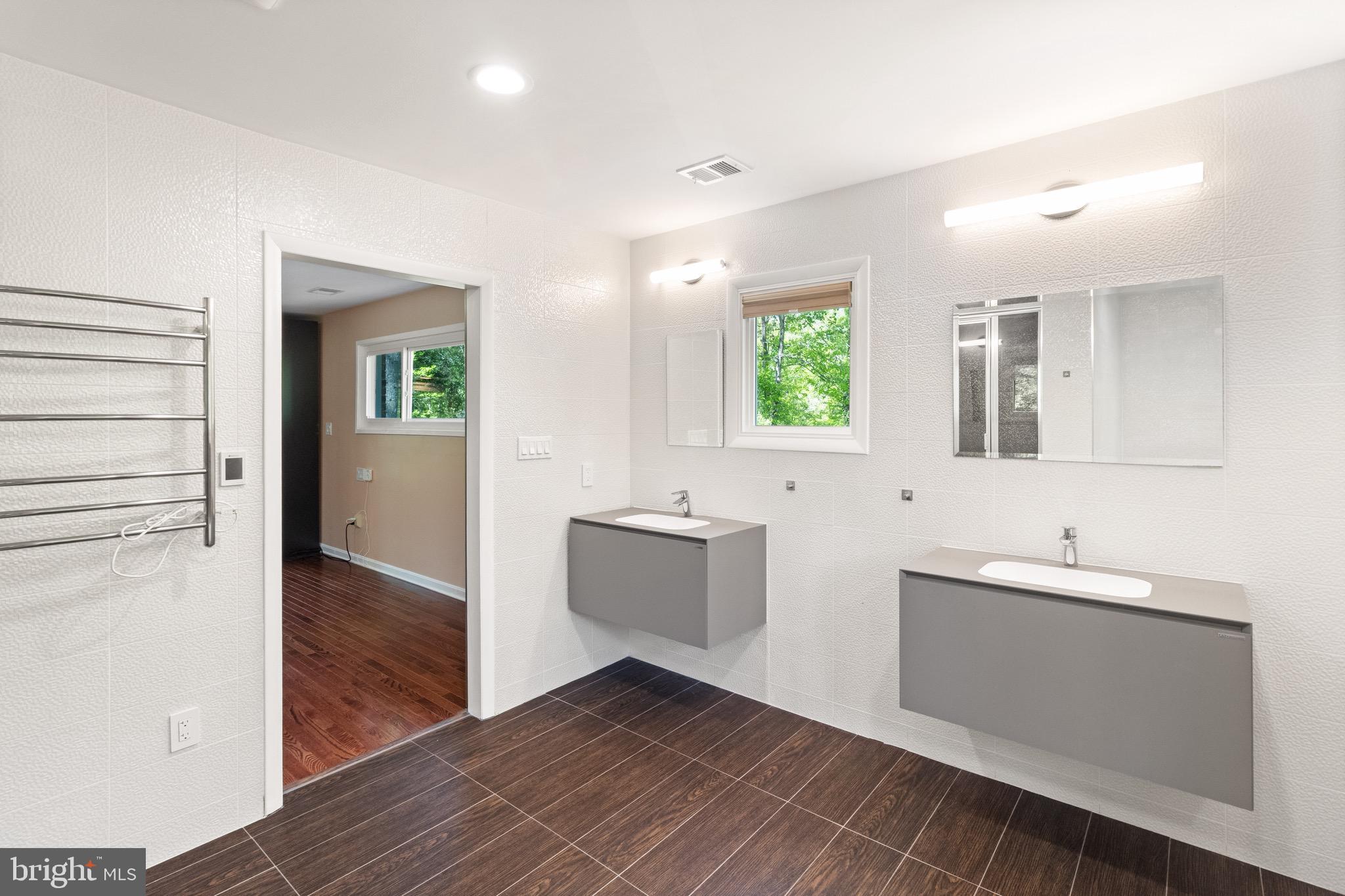 9220 Beech Hill Drive Bethesda, MD 20817 - Photo 25 of 50 a bathroom with a double vanity sink a toilet and mirror