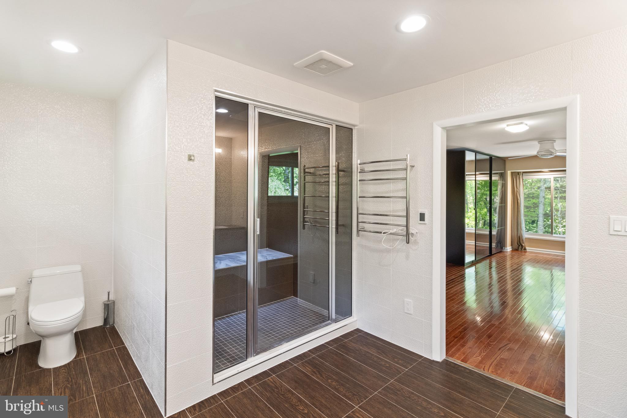 9220 Beech Hill Drive Bethesda, MD 20817 - Photo 27 of 50 a bathroom with a glass shower door and a toilet
