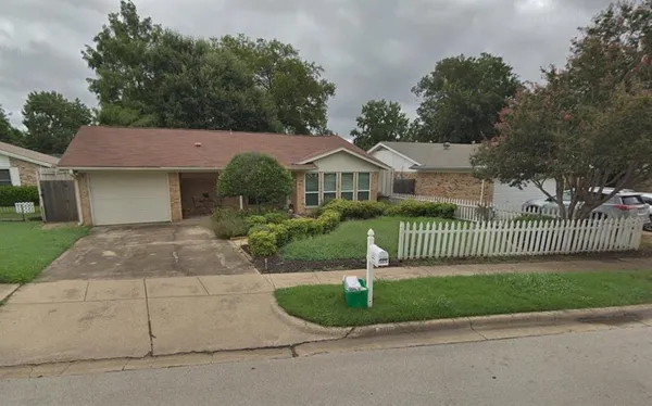a front view of a house with a garden and plants