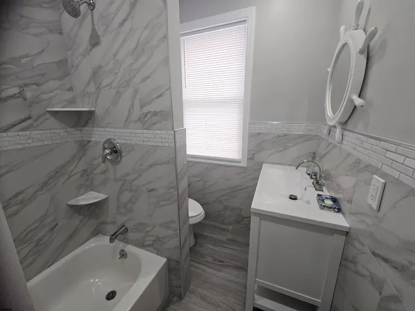 a bathroom with a sink a window and shower