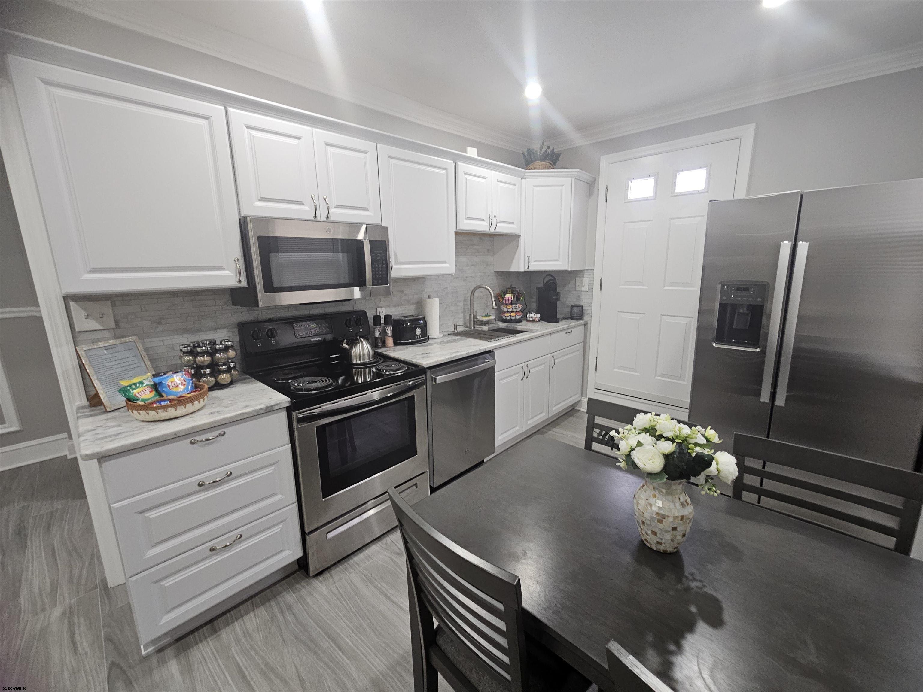 4009 Ventnor, Unit 2 Atlantic City, NJ 08401 - Photo 16 of 32 a kitchen with a sink stainless steel appliances and cabinets