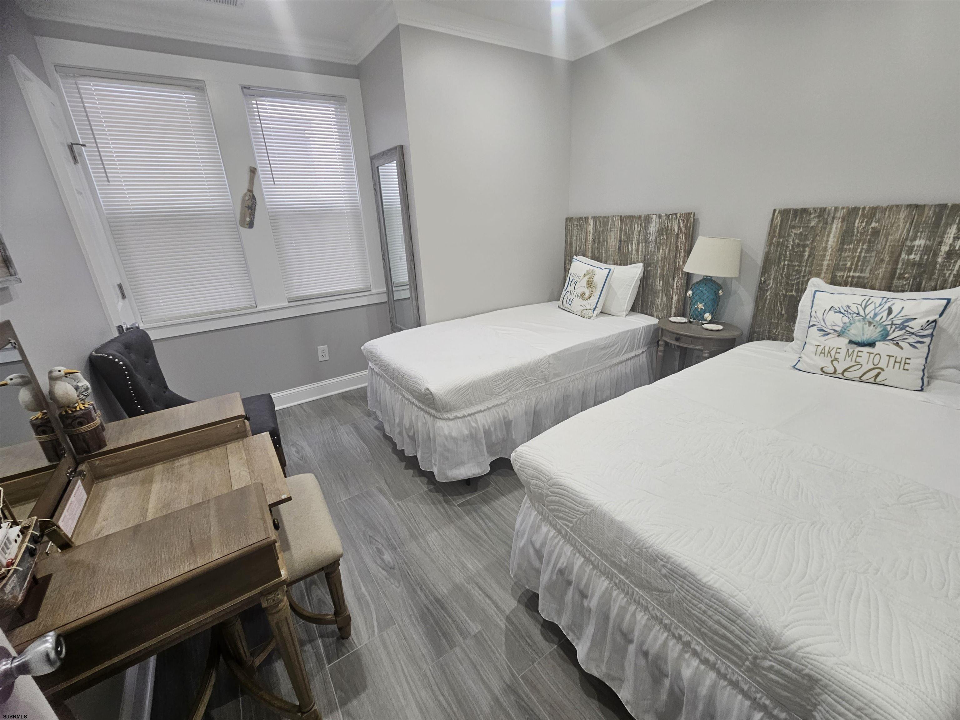 4009 Ventnor, Unit 2 Atlantic City, NJ 08401 - Photo 17 of 32 a bedroom with two beds and wooden floor