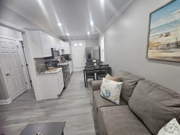 a living room with furniture and kitchen view