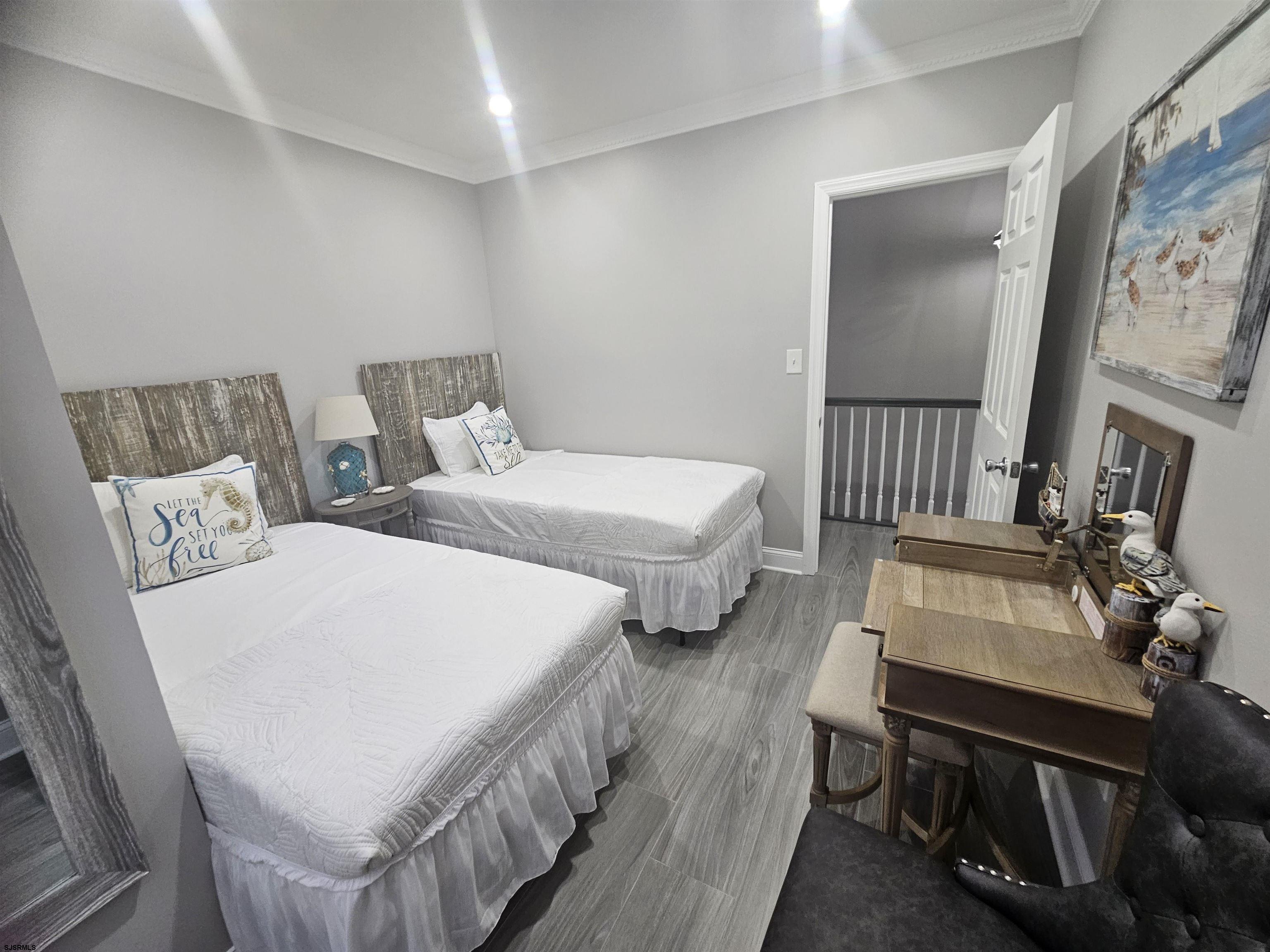 4009 Ventnor, Unit 2 Atlantic City, NJ 08401 - Photo 20 of 32 a bedroom with two beds a couch and a dresser with wooden floor