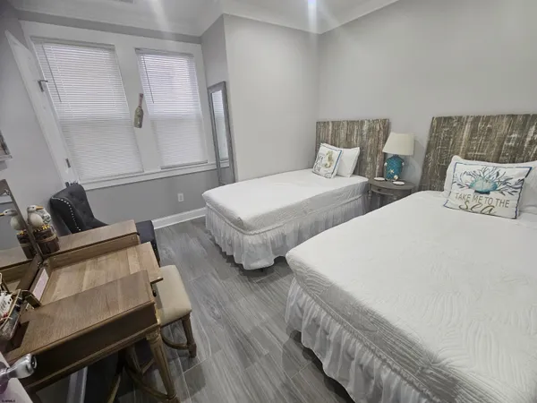 a bedroom with two beds and wooden floor