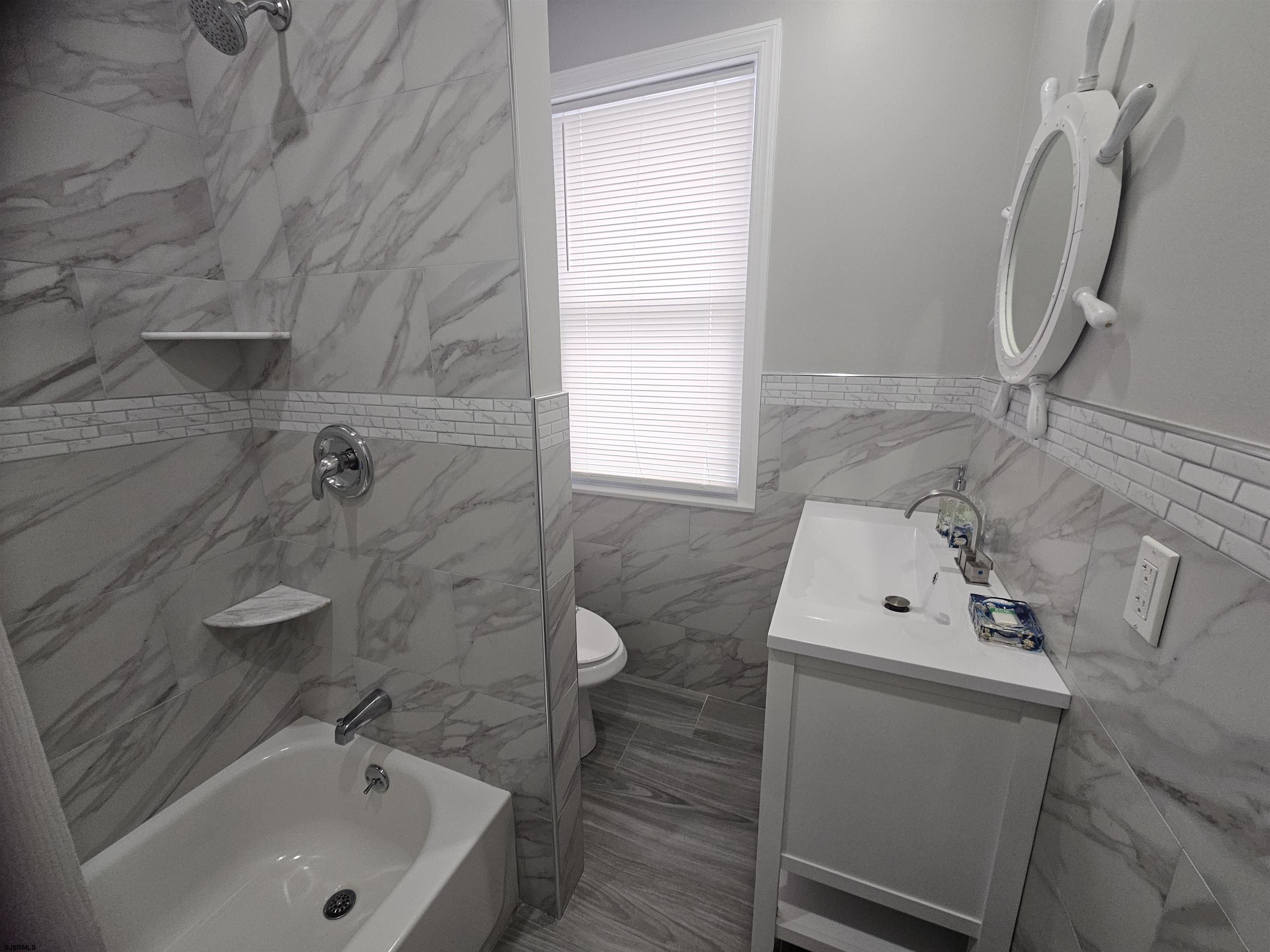 4009 Ventnor, Unit 2 Atlantic City, NJ 08401 - Photo 28 of 32 a bathroom with a sink a window and shower