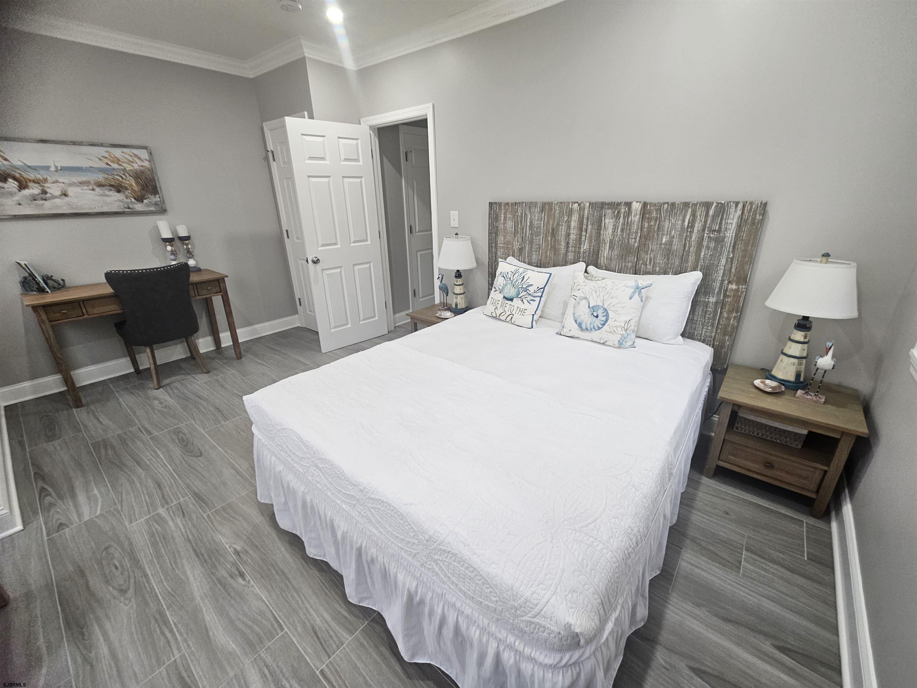 4009 Ventnor, Unit 2 Atlantic City, NJ 08401 - Photo 29 of 32 a bedroom with a bed and wooden floor