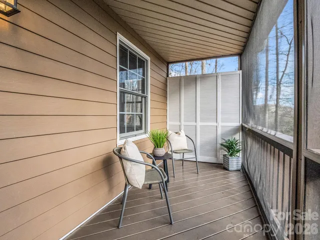 a balcony with chairs and wooden floor