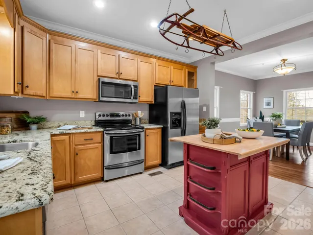 a kitchen with stainless steel appliances granite countertop a stove top oven a sink a counter space and cabinets
