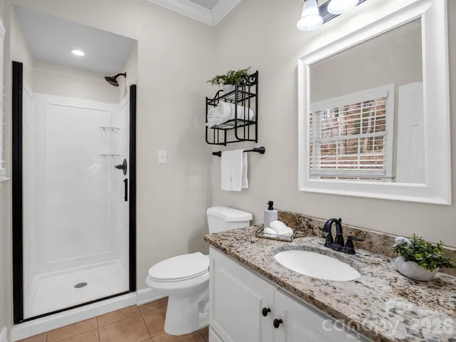 a bathroom with a granite countertop sink mirror vanity and toilet