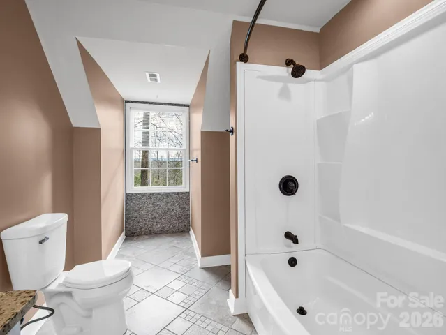 a bathroom with a bathtub a toilet and a shower