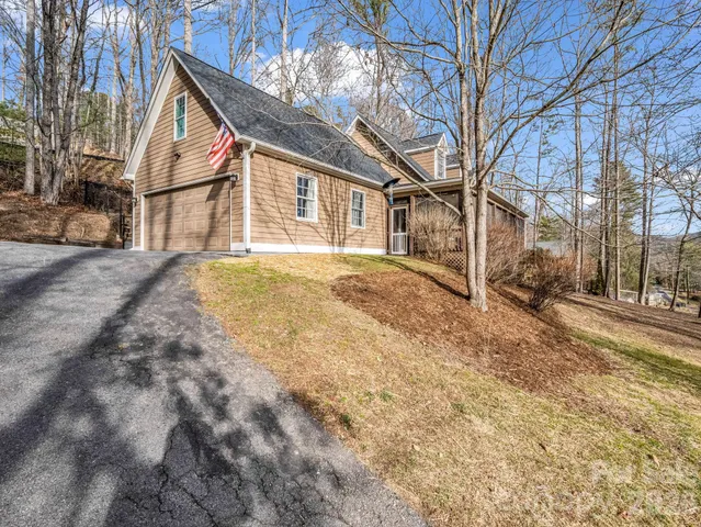 a view of a yard in front of a house with a large tree