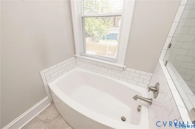 a white bath tub sitting next to a window