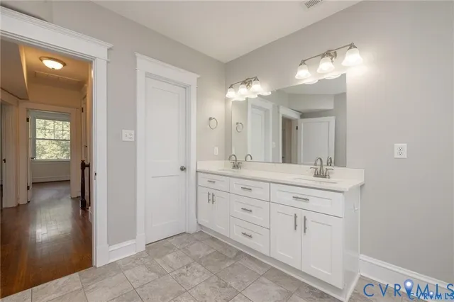a bathroom with a double vanity sink and a mirror