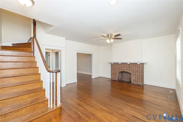 a view of a livingroom with wooden floor and a ceiling fan