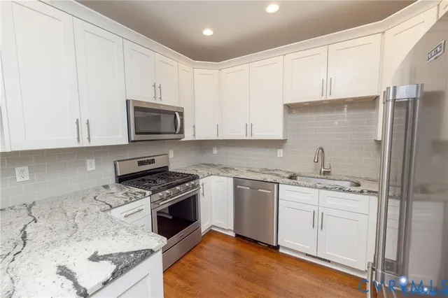 a kitchen with stainless steel appliances granite countertop a stove a sink and a microwave