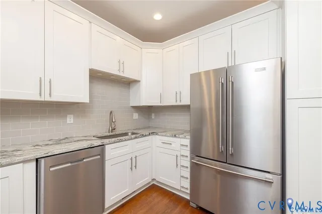 a kitchen with stainless steel appliances white cabinets and a refrigerator