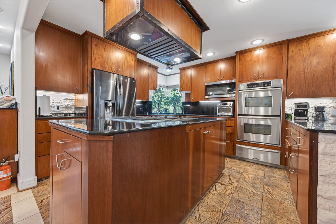 16914 Creeksouth Road Houston, TX 77068 - Photo 13 of 50 a kitchen with stainless steel appliances granite countertop a refrigerator and wooden cabinets