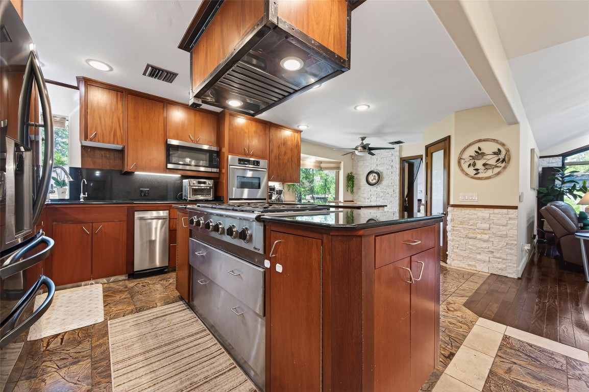 16914 Creeksouth Road Houston, TX 77068 - Photo 14 of 50 a kitchen with stainless steel appliances granite countertop a sink a stove and a wooden floors