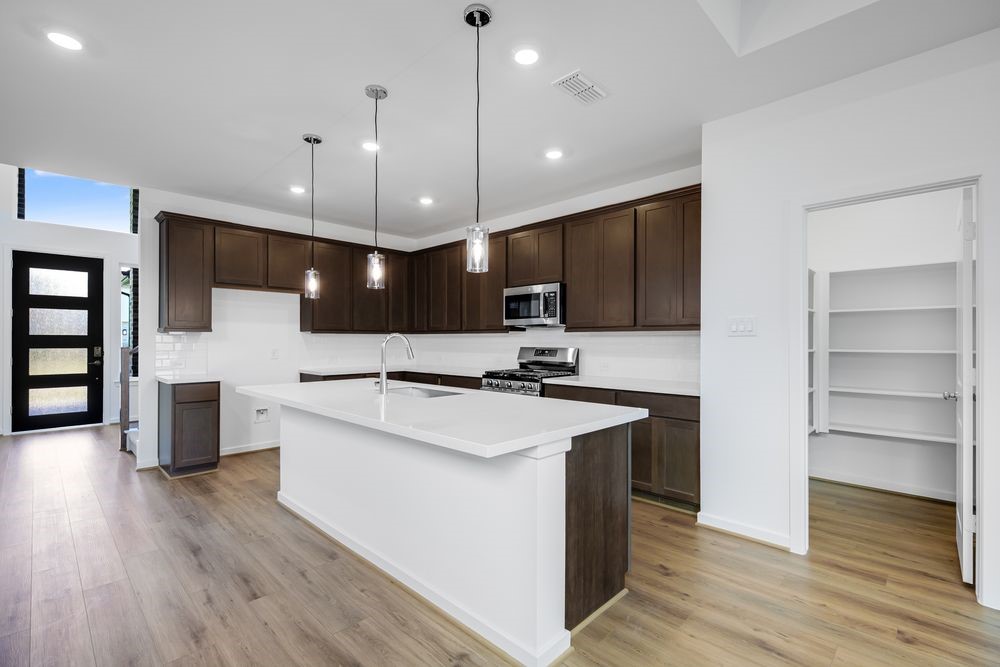 22119 Strathfield Circle Cypress, TX 77433 - Photo 2 of 37 a large kitchen with a center island wooden floor stainless steel appliances and cabinets