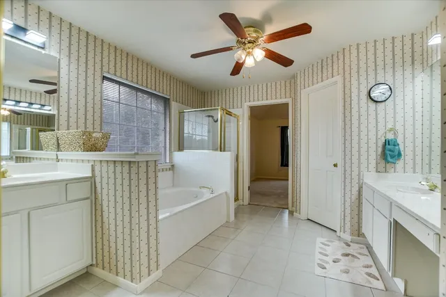 a bathroom with a tub a sink and a mirror