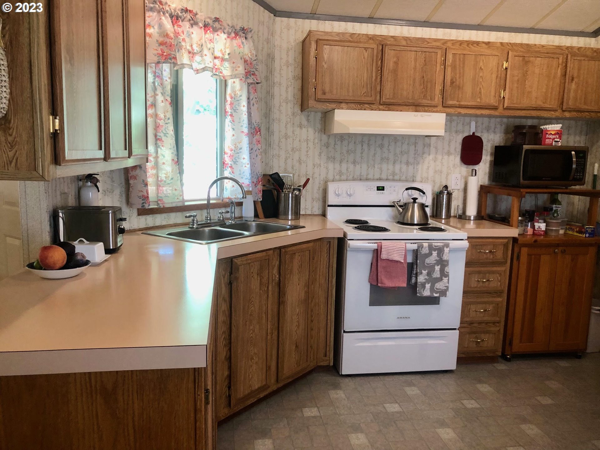 1809 26th Street, Unit 77 La Grande, OR 97850 - Photo 8 of 41 a kitchen with stainless steel appliances a stove a sink and a microwave