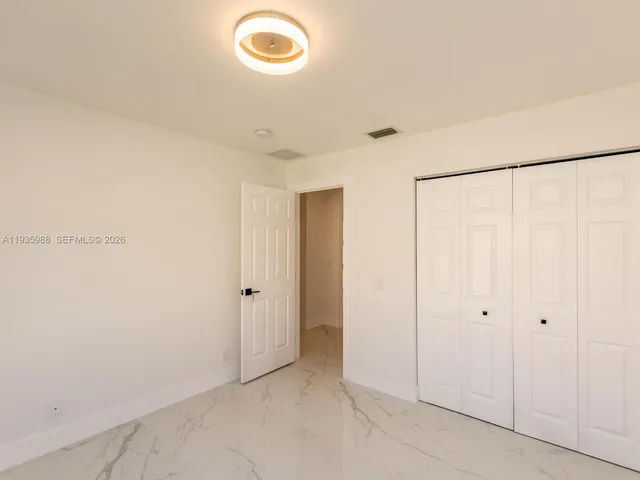 a bathroom with a granite countertop sink a mirror and a toilet