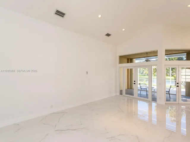 a large white kitchen with kitchen island white cabinets and stainless steel appliances