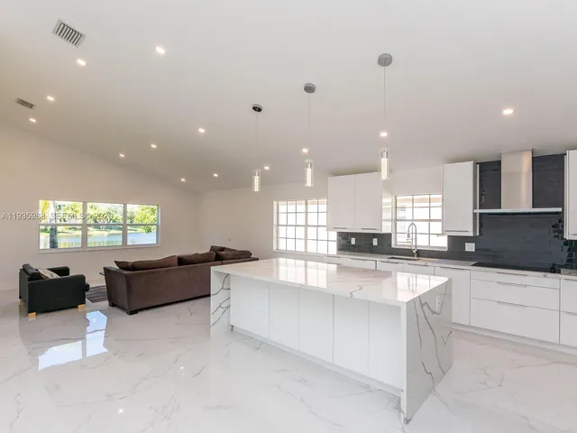 a living room with furniture and a view of kitchen