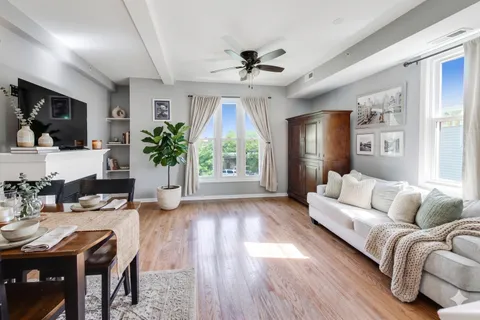 a living room with furniture a flat screen tv and a large window