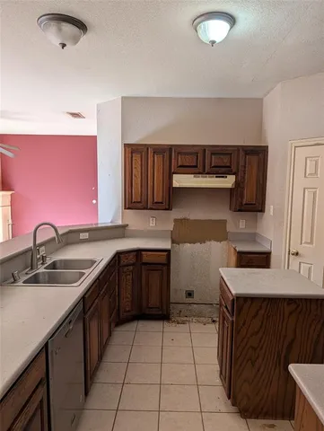 a kitchen with a sink a stove and cabinets