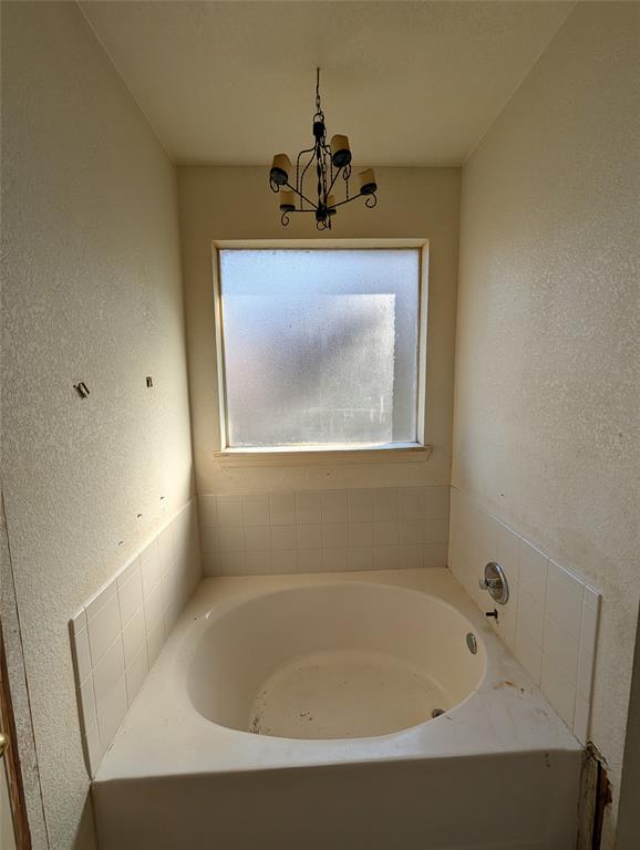 2301 Springmere Drive Arlington, TX 76012 - Photo 24 of 34 a bath tub sitting in a bathroom next to a sink