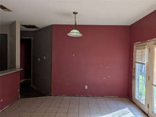 a view of a livingroom with a red door and wooden cabinets