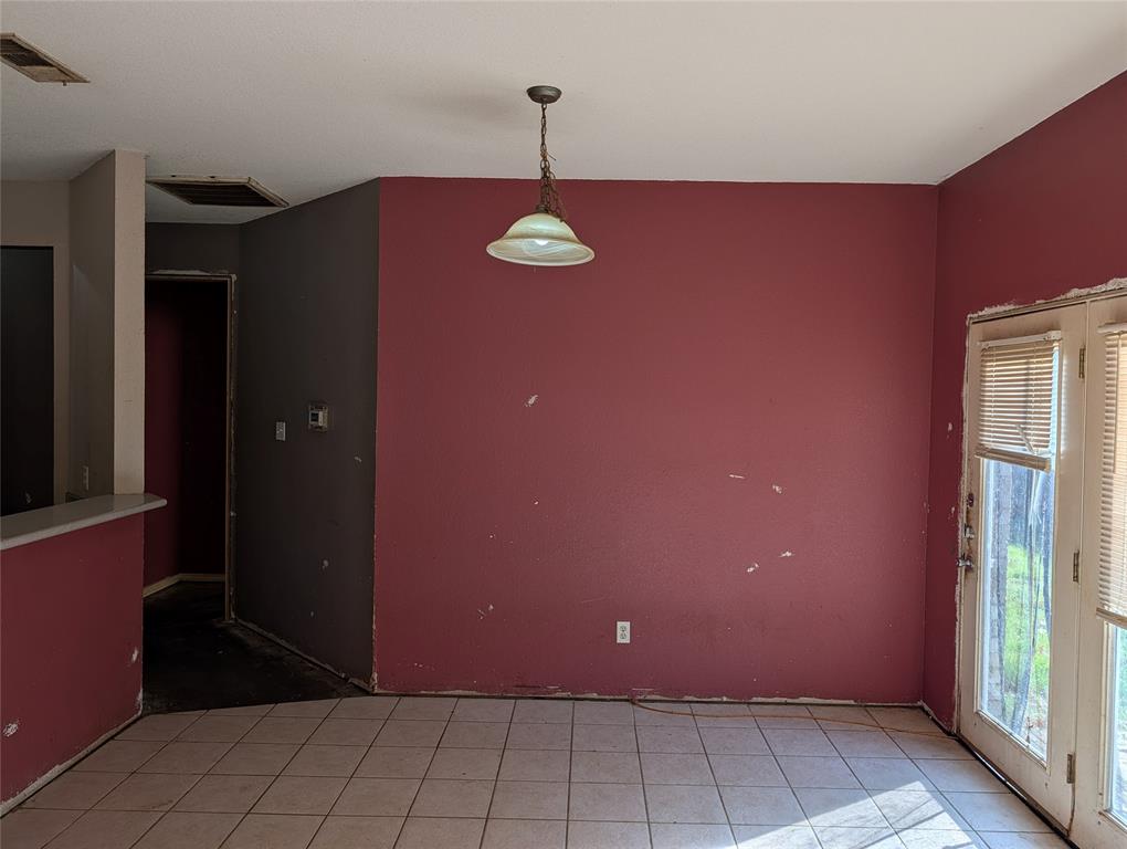 2301 Springmere Drive Arlington, TX 76012 - Photo 8 of 34 a view of a livingroom with a red door and wooden cabinets