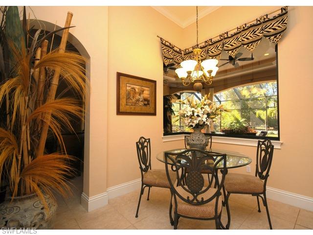 1491 Oakes Boulevard Naples, FL 34119 - Photo 4 of 15 a dining room with furniture a chandelier and window