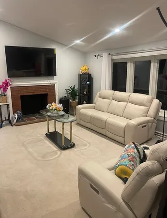 a living room with furniture a fireplace and a flat screen tv