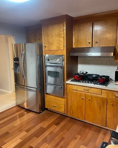 a kitchen with a refrigerator and a stove top oven