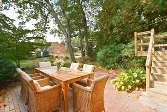 a view of a patio with table and chairs and potted plants with wooden fence