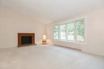 an empty room with windows and a fireplace