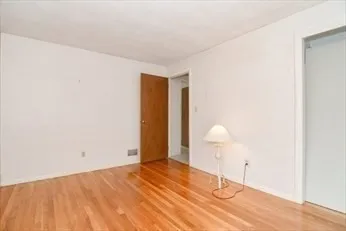 a view of a room with wooden floor and white walls