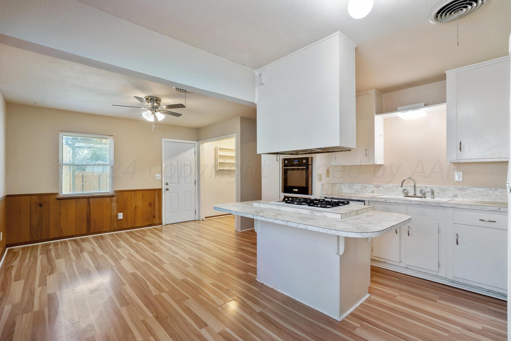 4419 Bowie Street Amarillo, TX 79110 - Photo 4 of 15 a kitchen with wooden floors and cabinets