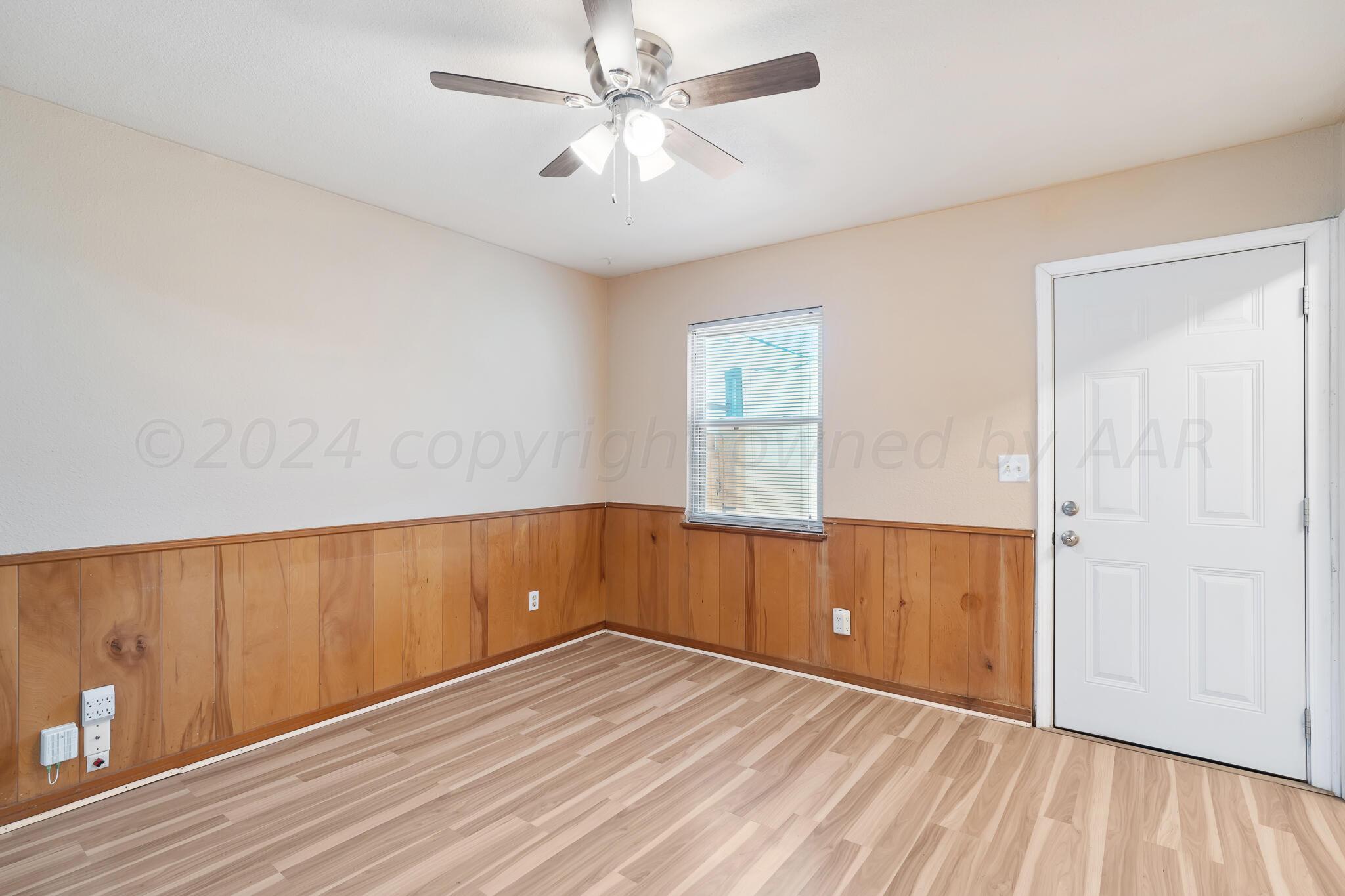 4419 Bowie Street Amarillo, TX 79110 - Photo 5 of 15 wooden floor in an empty room with a window