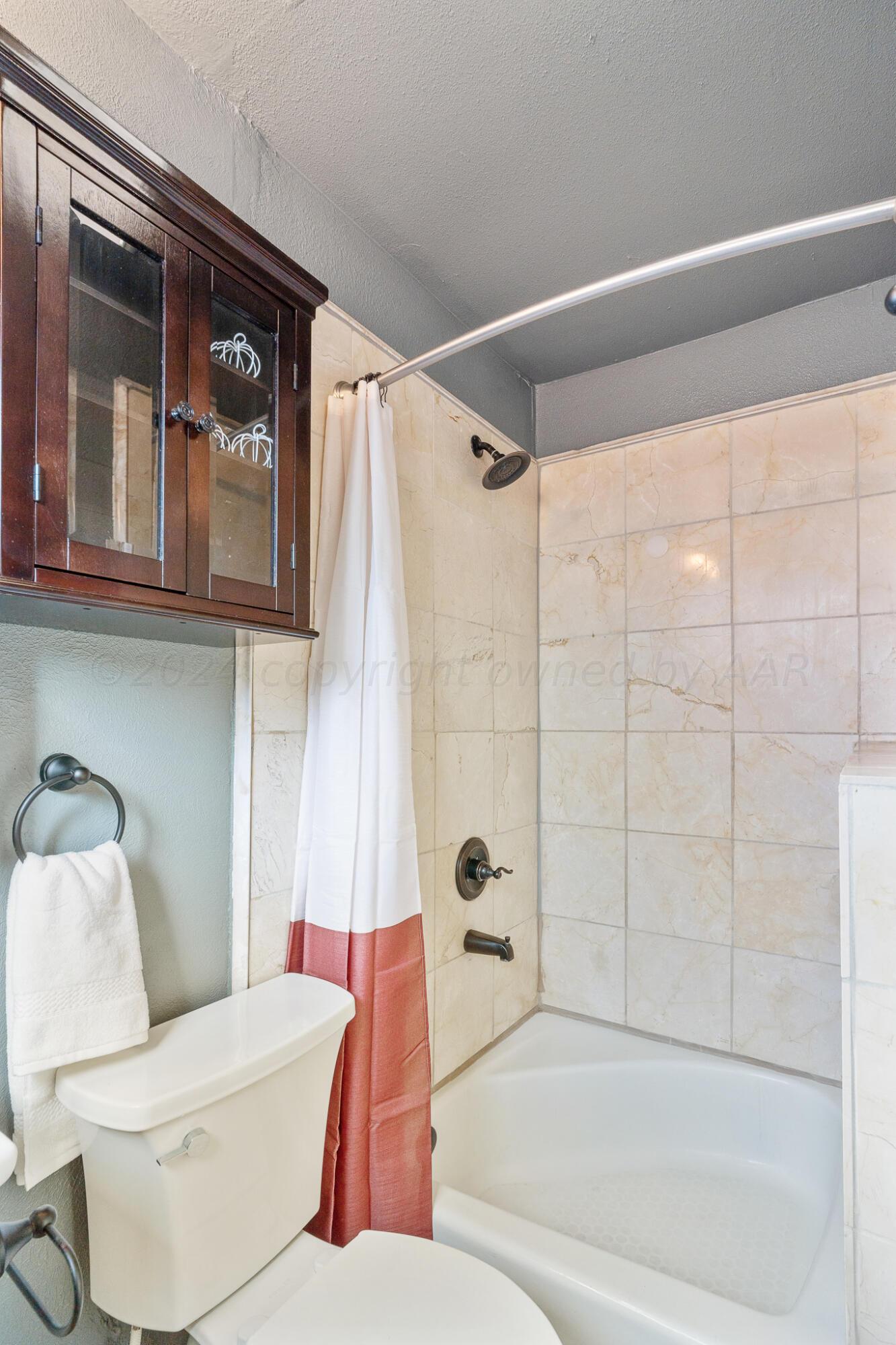 4419 Bowie Street Amarillo, TX 79110 - Photo 8 of 15 a white toilet sitting next to a bathroom sink and tub