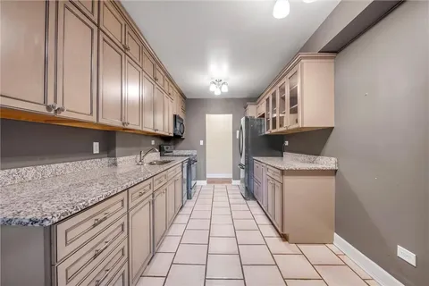 a kitchen with stainless steel appliances granite countertop a sink stove and cabinets