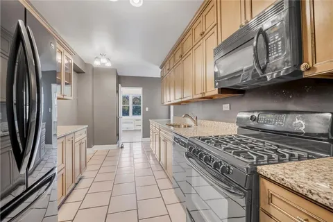 a kitchen with stainless steel appliances granite countertop a stove a refrigerator and cabinets