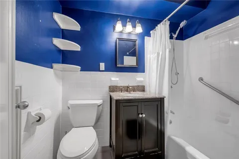 a bathroom with a toilet sink shower and mirror