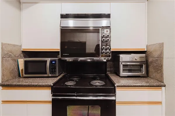 a kitchen with stainless steel appliances granite countertop a refrigerator and a stove top oven