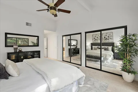 a bedroom with a large bed and a flat tv screen