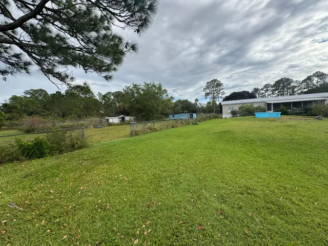 a view of a chair and table in backyard of the house