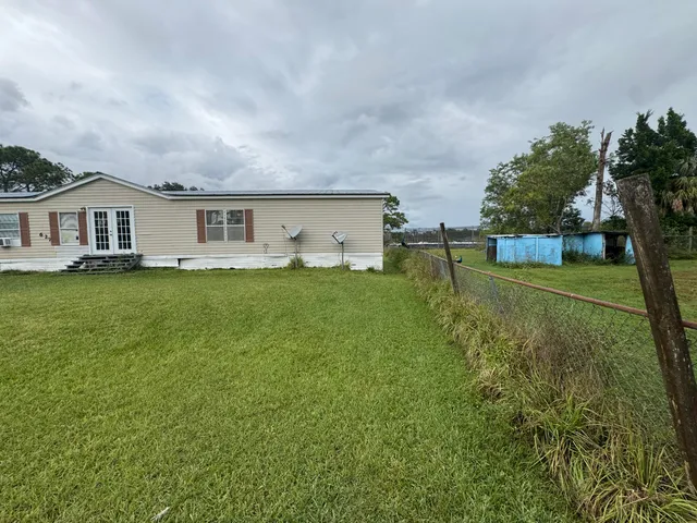 a view of a house with a yard and sitting area